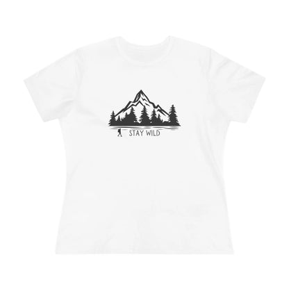 White t-shirt with black mountain and tree graphic and 'Stay Wild' text on a white background